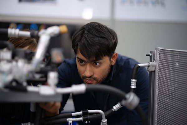 Mechanics are working at EV car workshop. Mechanics are working at EV car workshop. Engine and parts at EV car workshop.